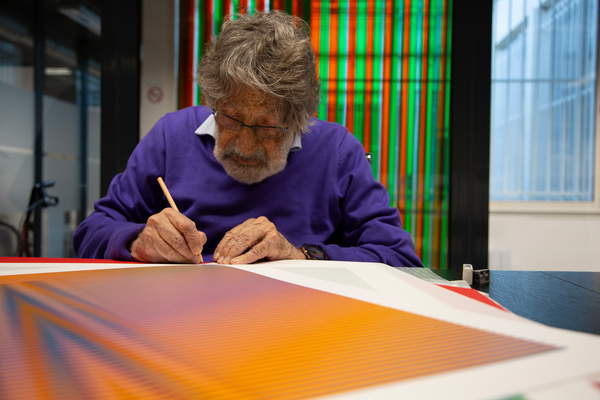 Carlos Cruz-Diez signing an Induction Chromatique à double fréquence Lucca, 2018 (silkscreen on paper), Cruz-Diez, Carlos (1923-2019)  © Estate of Carlos Cruz-Diez. All rights reserved 2021  Bridgeman Images 